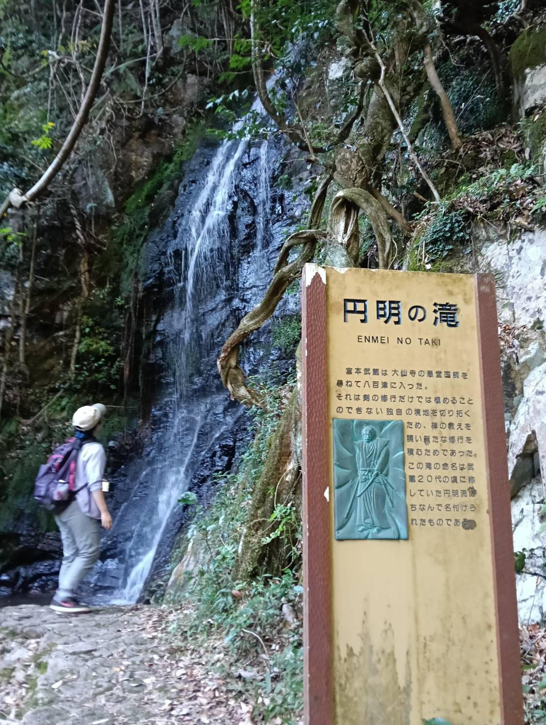 円明の滝の流れと、宮本武蔵の伝説を記した看板